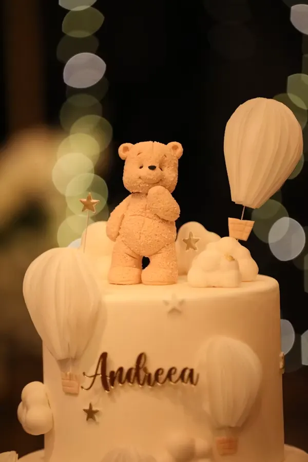 Cream teddy bear baby shower cake with fondant clouds, stars and hot air balloon toppers