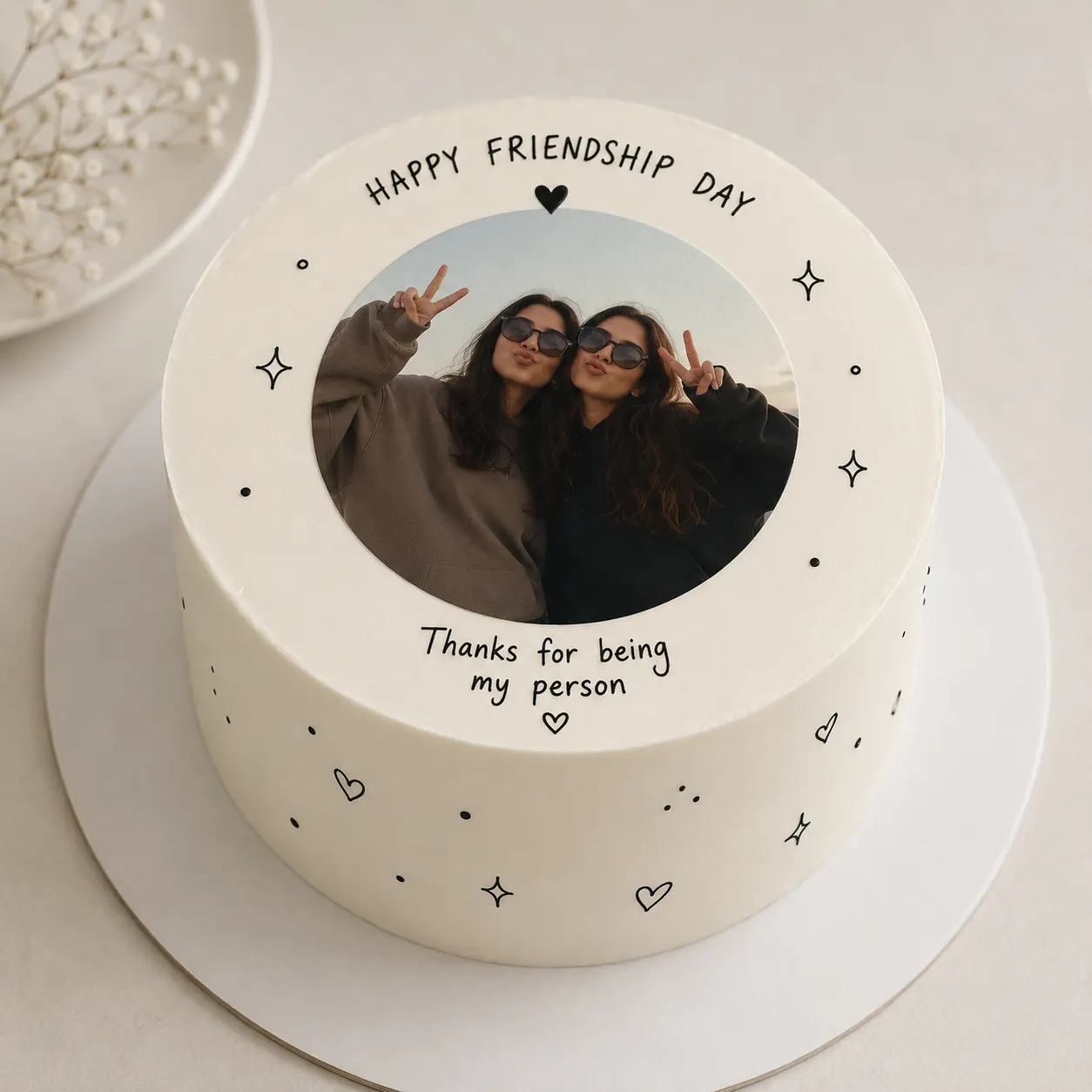 Minimalist white cake with a photo of two friends and the message Happy Friendship Day, thanks for being my person