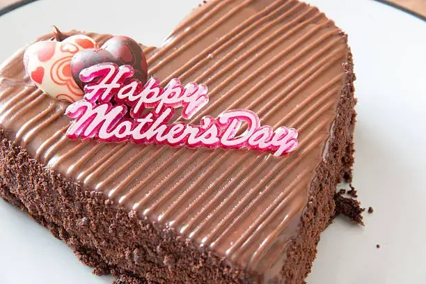 Heart-shaped chocolate cake with ridged chocolate ganache, a chocolate heart decoration and a 'Happy Mother's Day' topper